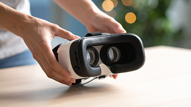 VRヘッドセットを手に持つ